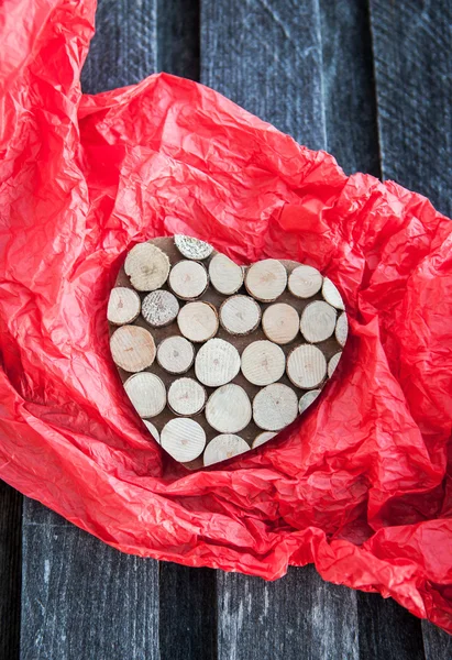 Coeur en bois dans le papier cadeau rouge — Photo