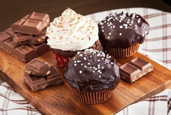 Chocolate cupcakes decorated with glaze and cream — Stock Photo, Image