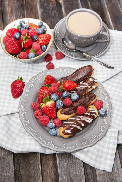 Шоколадные эклеры со свежими ягодами — стоковое фото
