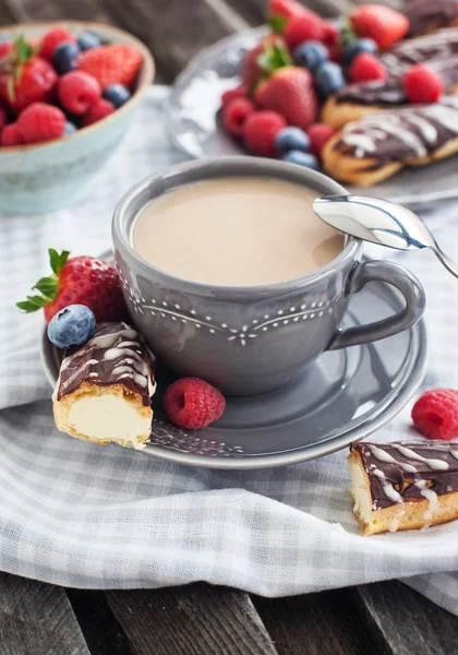 Cup of coffee and chocolate eclairs — Stock Photo, Image