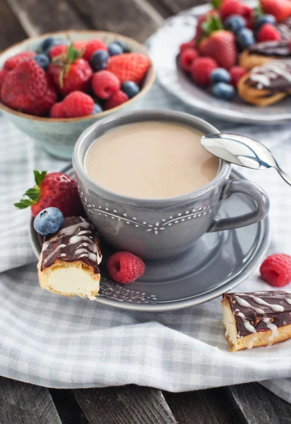 Cup of coffee and chocolate eclairs — Stock Photo, Image