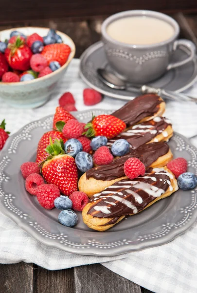 Шоколадные эклеры со свежими ягодами — стоковое фото