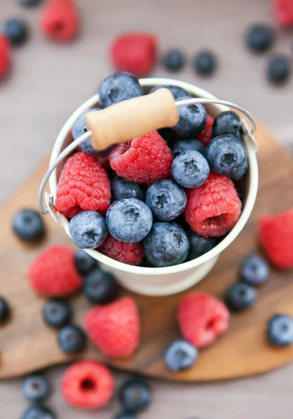 Fresh blueberries and raspberries in a  bucket — Stock Photo, Image