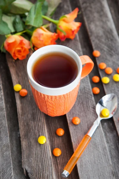 Csésze tea és színes cukorkák — Stock Fotó