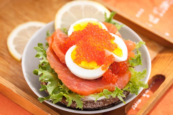 Сэндвич с соленым лососем, яйцом и красной икрой — стоковое фото