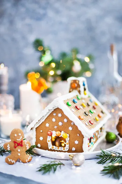 休日の装飾 キャンドルやランタンを背景に自家製のクリスマスジンジャーブレッドハウス — ストック写真