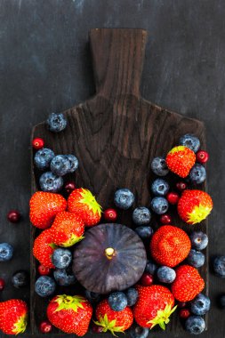 Taze çilek, yaban mersini ve incir, koyu arka planda, üst tarafta.