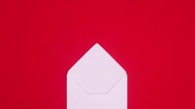 Noel süsleri kırmızı temalı beyaz zarftan görünür. Hareketi durdur