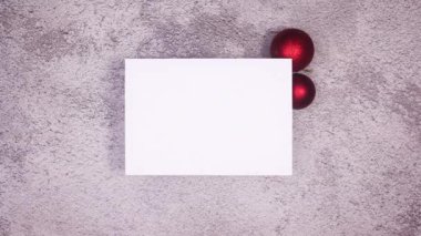 Gri temalı kağıdın altında kırmızı farklı Noel süsleri beliriyor. Hareketi durdur