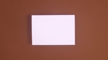 Noel süsleri kahverengi temalı kağıdın etrafında belirir. Hareketi durdur