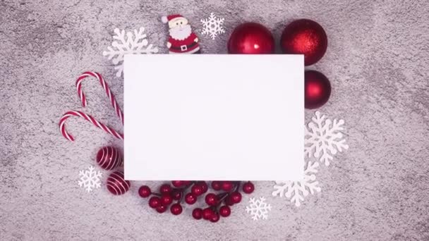 Prázdný papír pro text obklopený vánočními ozdobami a cukrovinkami. Zastavit pohyb