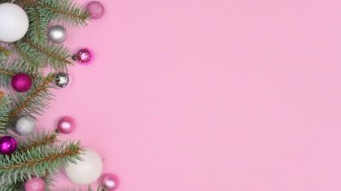 Pembe ve beyaz Noel süsleri pastel pembe temanın sol tarafındaki çam ağacında görünür. Hareketi durdur
