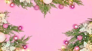Çam ağacında, pembe süslemeli ve pembe temalı beyaz çiçeklerle Noel aranjmanında yanıp sönen ışıklar. Hareketi durdur