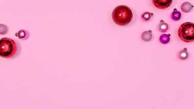 Kırmızı ve pembe Noel balolarının pastel pembe temalı minimum Noel düzenlemesi. Hareketi durdur