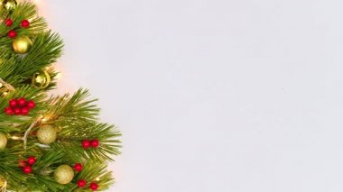 Altın sarısı Noel çam dallarında yanıp sönen ışıklar, altın süsler ve kutsal çilekler. Hareketi durdur