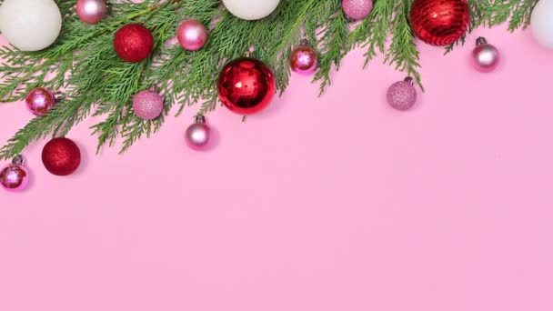 赤ピンクと白のクリスマスの装飾品は パステルピンクのテーマの上にクリスマス松のガーランドが付属しています 動くな — ストック動画