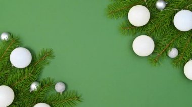 Yeni yılın dekoratif doğal çam dalları yeşil temanın sol ve sağ tarafında beyaz gümüş süslemelerle görünür ve dekore edilir. Hareketi durdur