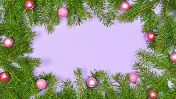 带有松枝和粉色装饰品的装饰圣诞框架呈现在紫色主题上 停止运动 — 图库视频影像