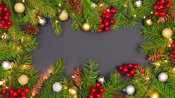 自然圣诞框架松树枝条 冬青浆果 松果和闪烁的灯光的黑色主题 停止运动 — 图库视频影像
