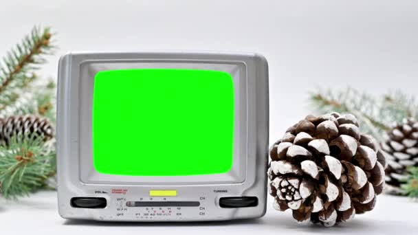 带有绿色屏幕的复古电视出现在白色的主题上 用圆锥和螺钉装饰圣诞 停止运动 — 图库视频影像