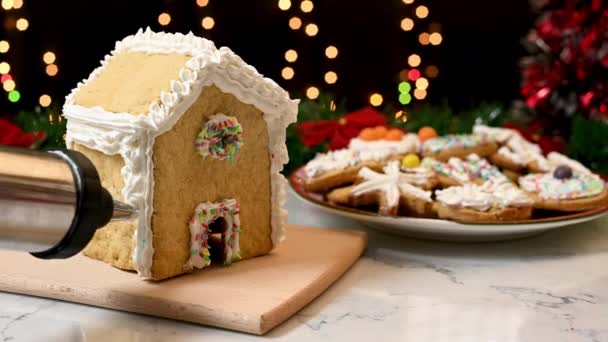 为圣诞节准备糖果 圣诞期间用白色奶油装饰姜饼屋 — 图库视频影像