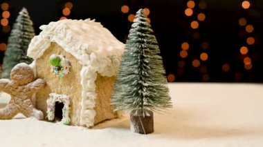 Masadaki Noel kurabiyelerinin harika düzenlemesi. Geleneksel Noel kurabiyesi evi ve pudra şekeri ve küçük Noel ağaçlarıyla süslenmiş erkek kurabiyeleri. Noel tatlıları