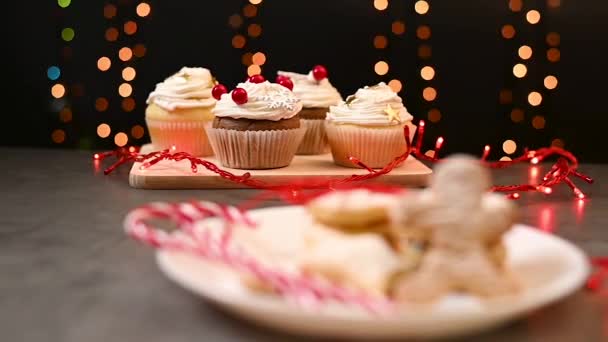 伝統的なおいしいクリスマスの家のテーブルはお菓子を提供しました クリスマステスティーカップケーキジンジャーブレッドクッキーの後ろのクリーム — ストック動画