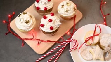 Noel tatlıları masada servis edilir. Zencefilli kurabiye, kek ve Noel süslemeleri ve yanıp sönen ışıklar olan baston şekerler.