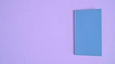 Mavi ciltli klasik kitap mor temalı ve açık. Dur hareketi düz yatıyordu 