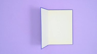 Mavi ciltli retro kitap mor temalı ve açık. Dur hareketi düz yatıyordu