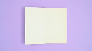 Beyaz ciltli kitap mor temalı, kapalı ve açık. Dur hareketi düz yatıyordu