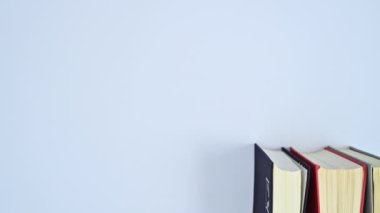 Kitap rafında farklı renklerde ciltli kitap yığını ve metin için boş alan. Dur hareketi düz yatıyordu