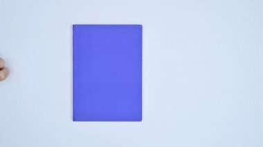El hareketi, ciltli mavi kitap ve kitap masanın üzerinde açılıyor. Dur hareketi düz yatıyordu 