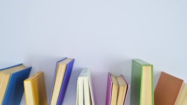 Canlı renklerde klasik ciltli kitaplar masanın üzerinde hareket ediyor. Lat lay stop motion 