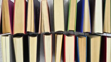 Ahşap masada iki sıra halinde sipariş edilen antika ciltli ciltli kitapların solgunluğu. Düz konum stop hareketi