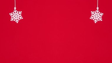 Kırmızı temaya kar taneleri asmak. Noel süslemeleri hareketi durdurur