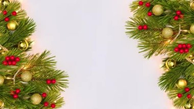 Noel aranjmanı. Sol ve sağ tarafta yanıp sönen ışıklar, köknar dalları ve kutsal meyvelerle. Hareketi durdur