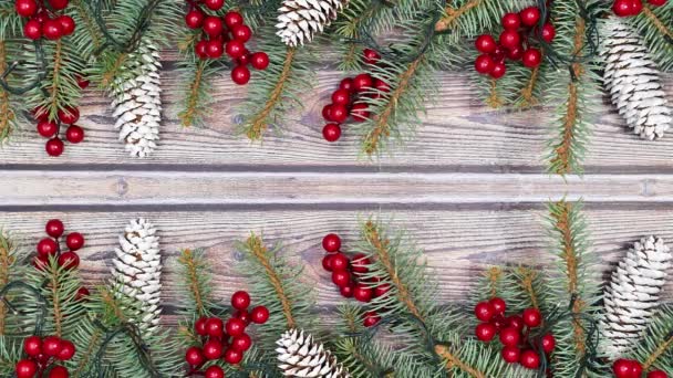 Weihnachtsschmuck mit Stechpalmen und Tannenzapfen auf Tannenzweigen mit blinkenden Lichtern zum Thema Holz. Stop-Motion