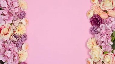 Pastel pembe temanın sol ve sağ tarafında bahar çiçekleri görünür. Hareketi durdur