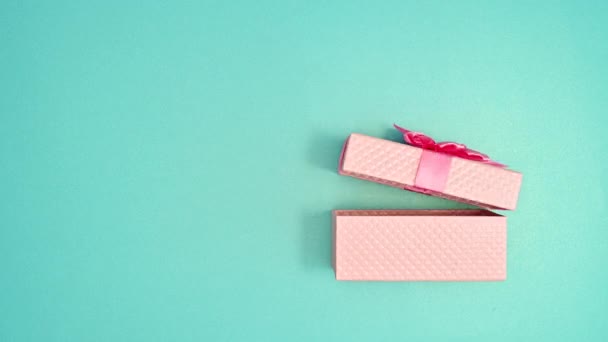 Пастельний Рожевий Подарунок Являється Відкривається Блакитному Фоні Зупинити Рух — стокове відео
