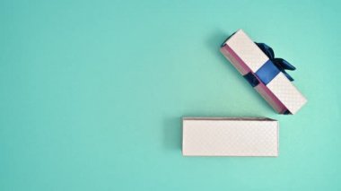 Koyu mavi kurdeleli gümüş hediye, arka planda görünür ve açılır. Hareketi durdur