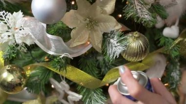 Noel ağacı dallarını Noel ve yeni yıl arifesi için sahte kar spreyiyle süslemek yavaş bir hareket.