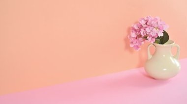 Açık turuncu pembe temalı ve vazoda bahar çiçekleri olan bir fincan kahveli waffle. Hareketi durdur