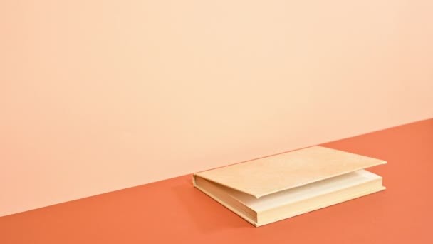 Hard Cover Vintage Book Erscheint Auf Tief Und Leuchtend Orange — Stockvideo