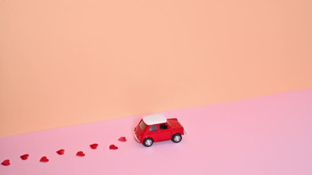 Маленькая Винтажная Красная Машина Проезжает Мимо Оставляет Красные Сердца Позади — стоковое видео