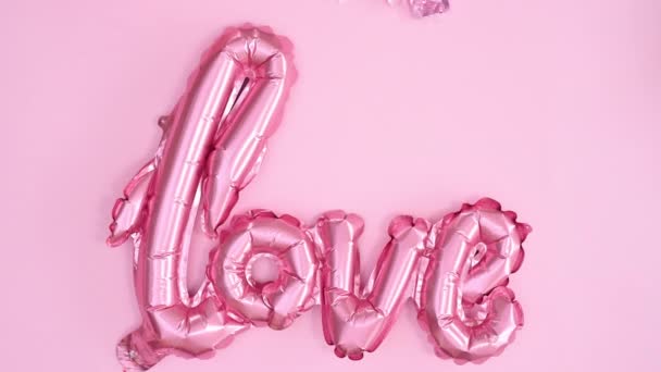 パステルピンクの愛の風船がパステルピンクのテーマに登場し 甘いカップケーキやバレンタインデーの装飾が周りに表示されます 動くな — ストック動画