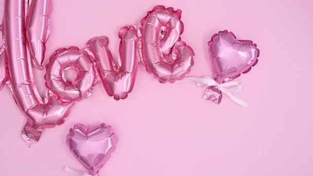バレンタインデーの愛の風船やギフト付きの甘いデザートは パステルピンクのテーマに登場します 動き平らなレイアウトを停止 — ストック動画