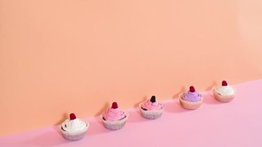 Turuncu pembe temalı ahududu ve kremalı leziz fincan kekleri. Hareketi durdur