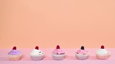 Turuncu pembe pastel temalı kremalı bir sürü tatlı kek. Hareketi durdur