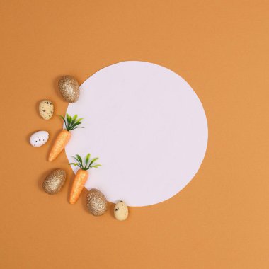 Turuncu havuçlu ve turuncu arkaplanlı altın yumurtalı yaratıcı kağıt kart notu. Paskalya minimumu düzleşmişti.